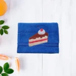 Blue cotton towel with embroidered slice of cake design