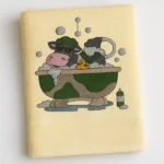 Cream cotton towel with cartoon cow taking a bubble bath embroidered design