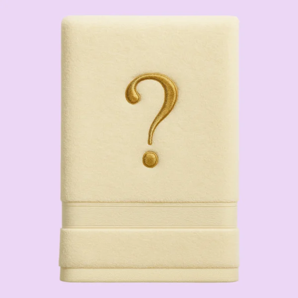 Cream towel with golden embroidered question mark on pastel background