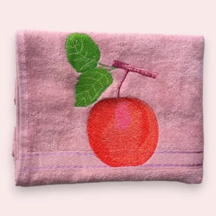 Pink cotton towel with embroidered red apple and green leaves design