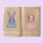 Beige towels with grey bunny and pink bunny with flower crown embroidery on pastel background