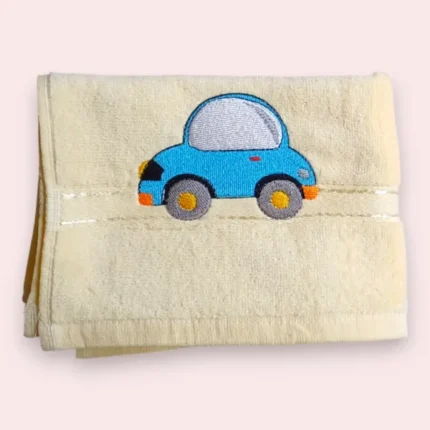 Light yellow towel with cute blue car embroidery on soft background