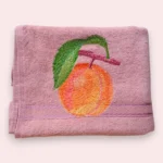 Pink cotton towel with embroidered orange fruit and green leaf design