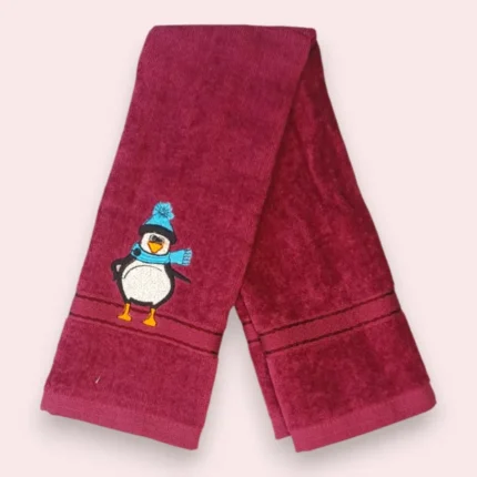 Maroon kids towel with cute winter penguin embroidery in blue hat and scarf