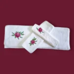 White towel set with pink rose embroidery on maroon background