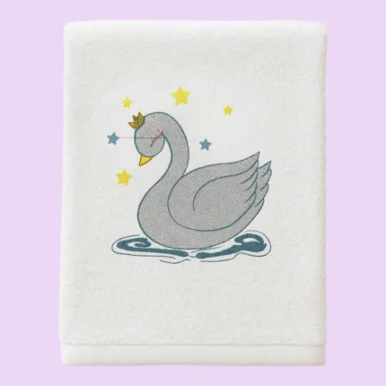 White towel with grey swan wearing a crown, surrounded by stars, on pastel background