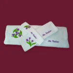 Personalized white towel set with purple tulip embroidery and “Ms. Bedair” name on maroon background
