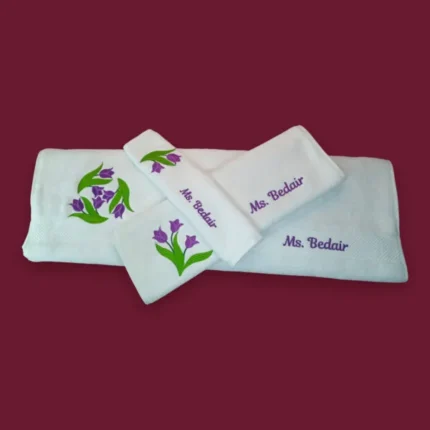 Personalized white towel set with purple tulip embroidery and “Ms. Bedair” name on maroon background